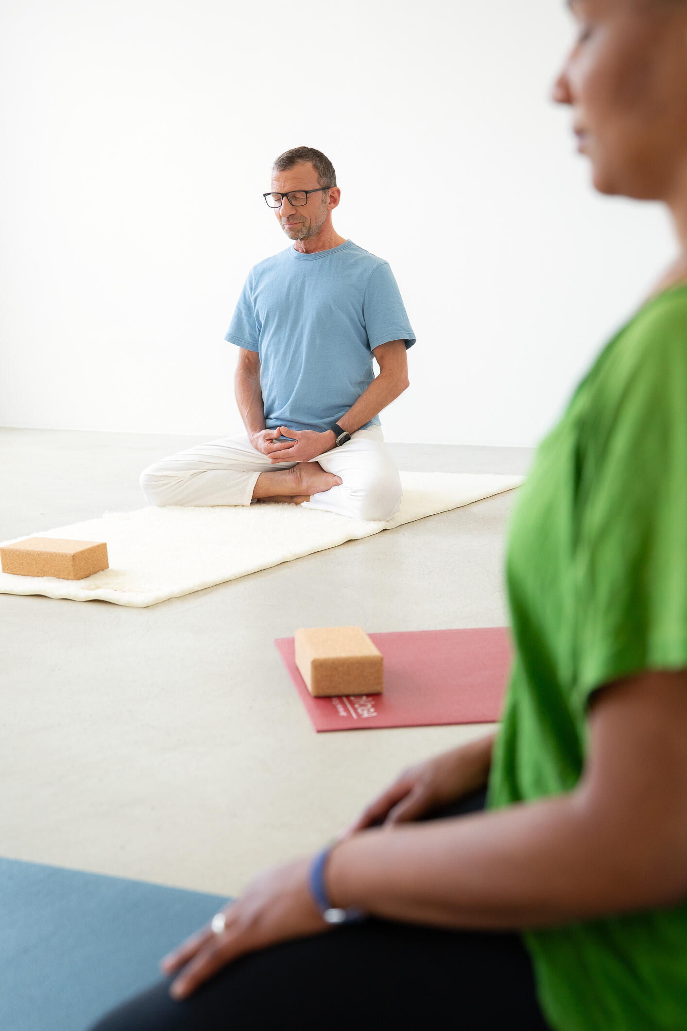 Yogalehrer mit Yogaschülerin in der Meditation